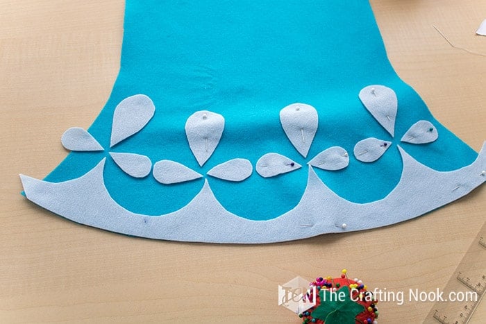 placing the decorations on the base of the dress with pins