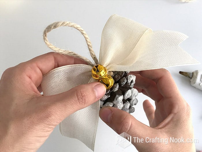 gluing the bow to the pinecone