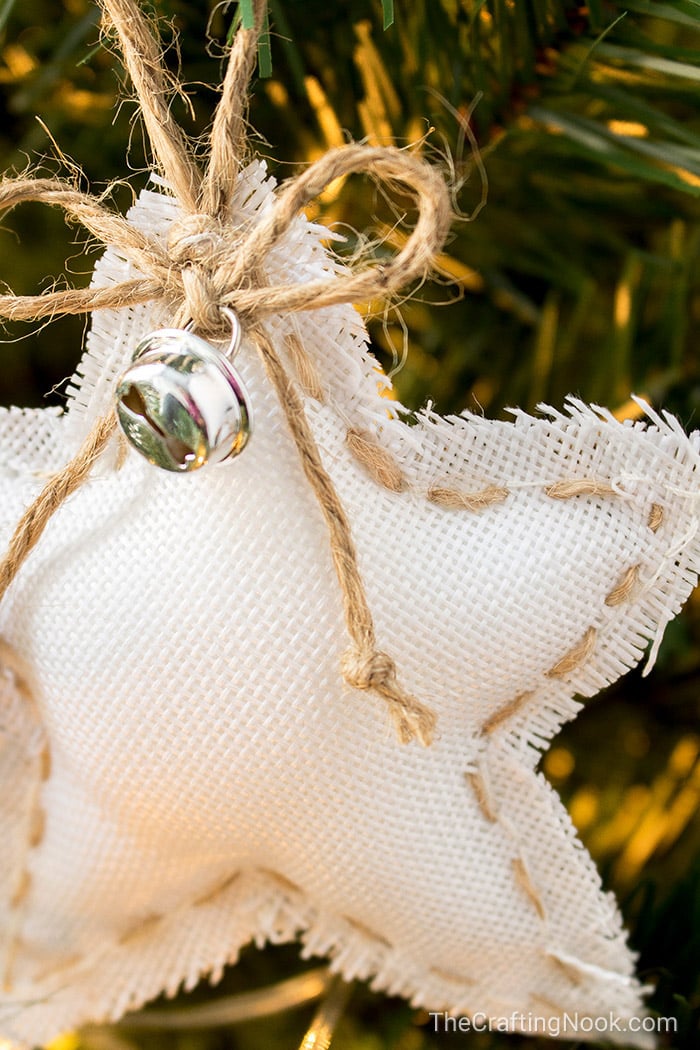 A closeup of the twine bow and jingle bell on the white star