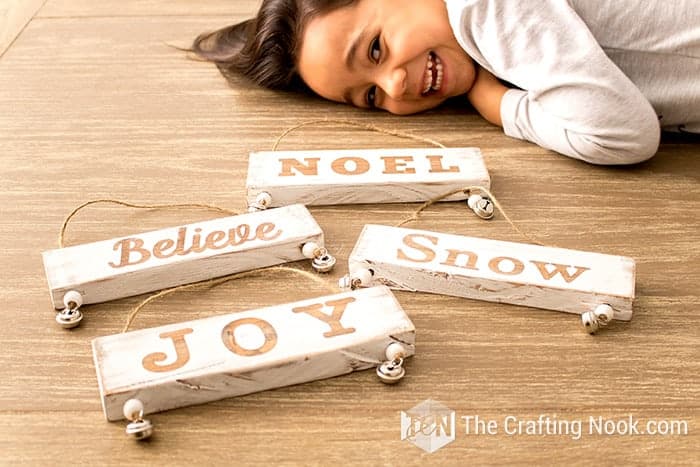 my daughter smiling and Mini Christmas Wood Sign Ornaments on the floor