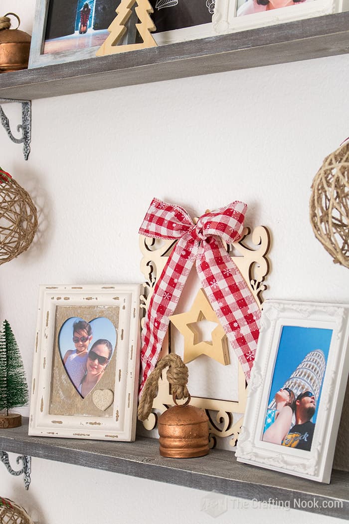 view of swirly wood frame with wood star on the center and plaid ribbon bow at the top