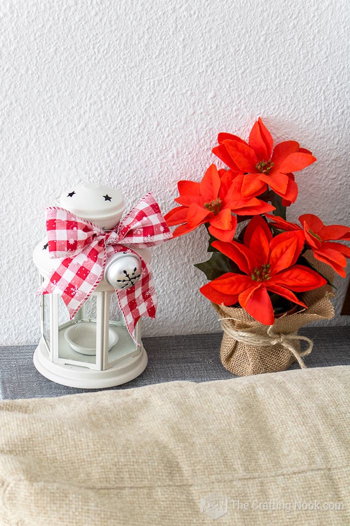 closer view of fake Christmas plant and a rustic white lantern