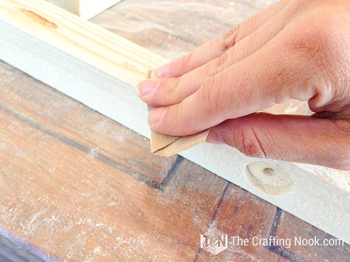 closer view of hand sanding the wood