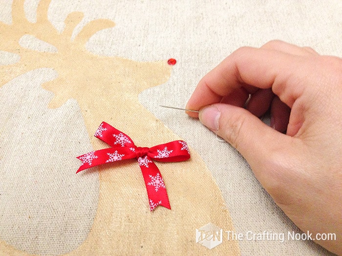 sewing the bow on gold reindeer