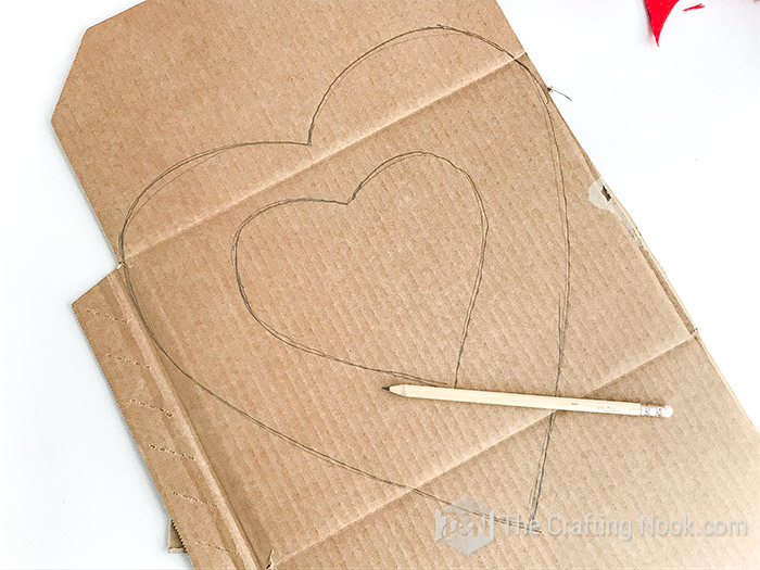 Hand drawing the heart shape on the cardboard