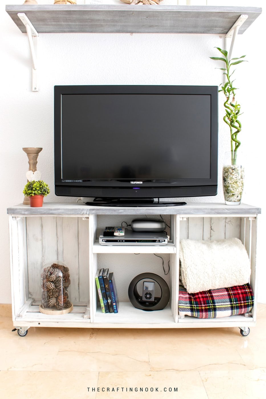 Front view of a farmhouse TV stand made from two distressed white wooden crates with open storage and a gray top.