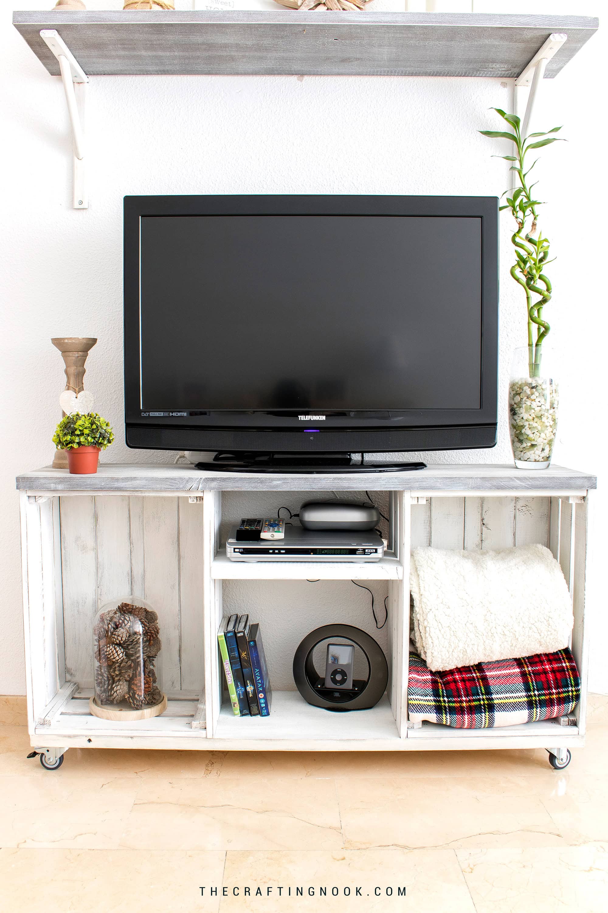 Front view of a farmhouse TV stand made from two distressed white wooden crates with open storage and a gray top.