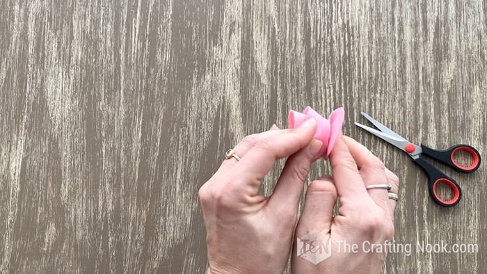 gluing the last piece of the spiral to secure the bottom of the felt flowers