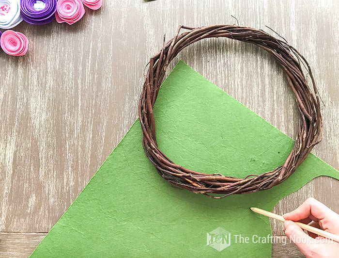 tracing the shape of the wreath on a green felt