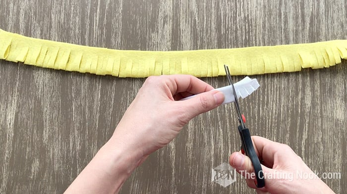 Cutting little slits into the folded shorter white felt