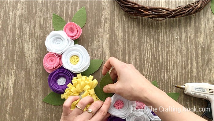 gluing the green leaves in between felt flowers