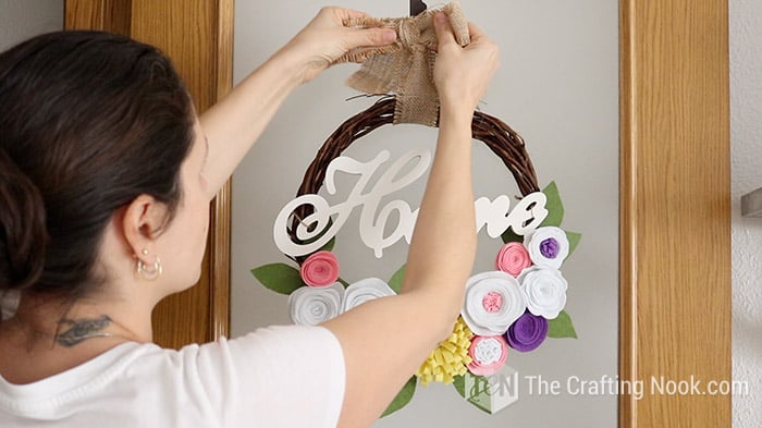 me hanging the Rustic Spring DIY Felt Flower Wreath on the door