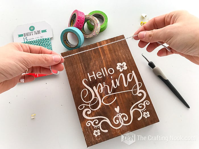 Decorating the woos sign with baker's twine and washi tape