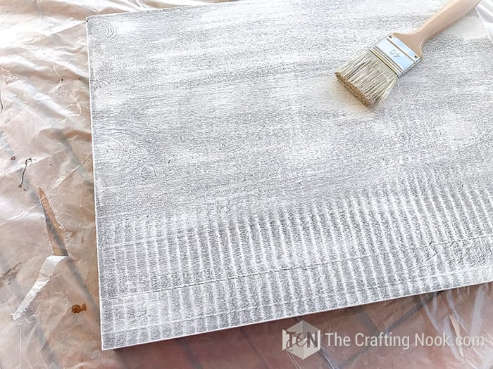 dry brushing with white paint to create distressed effect on a board