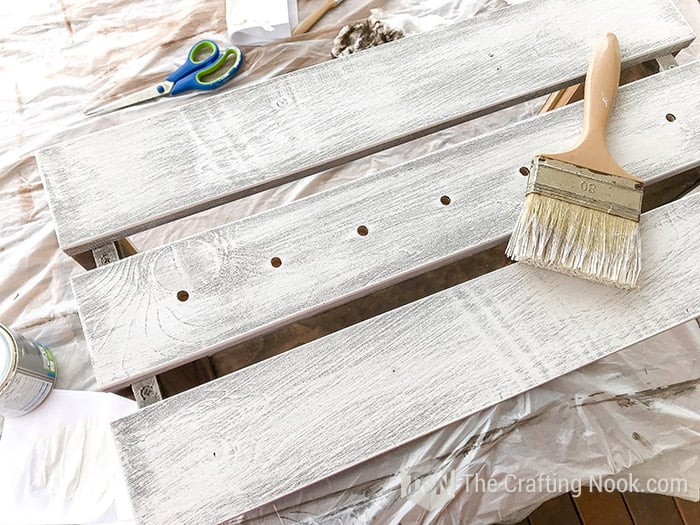 dry brushing with white paint to create distressed effect on a crate