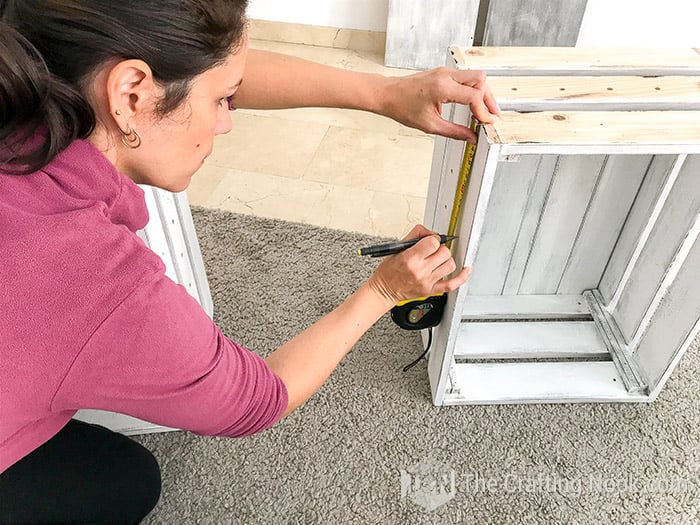 measuring the height of the center shelf on the other crate