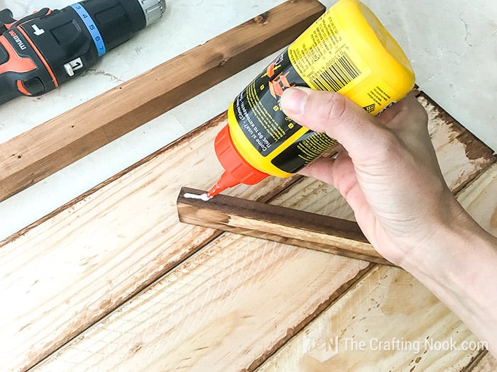 applying wood glue to one lumber