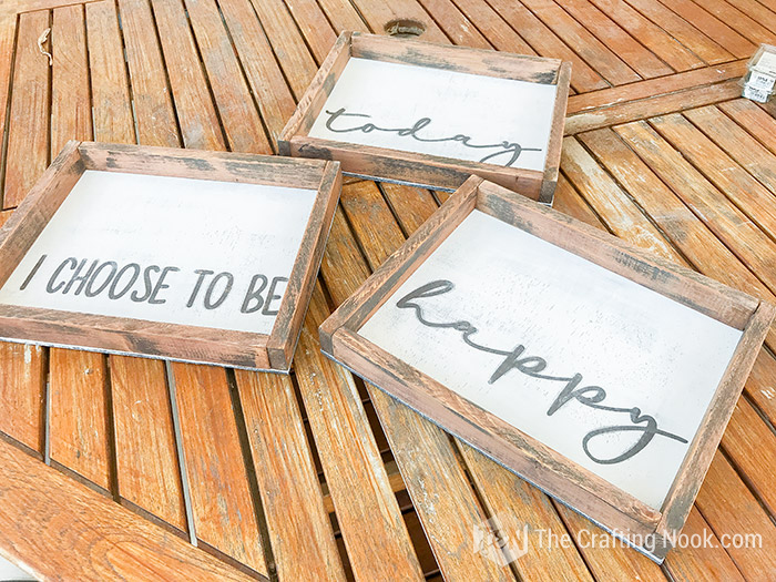 All three Farmhouse Wood Signs finished on the table