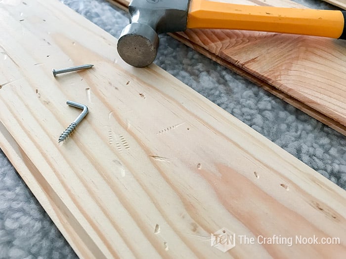 image of battered wood with a nail and screw and hammer