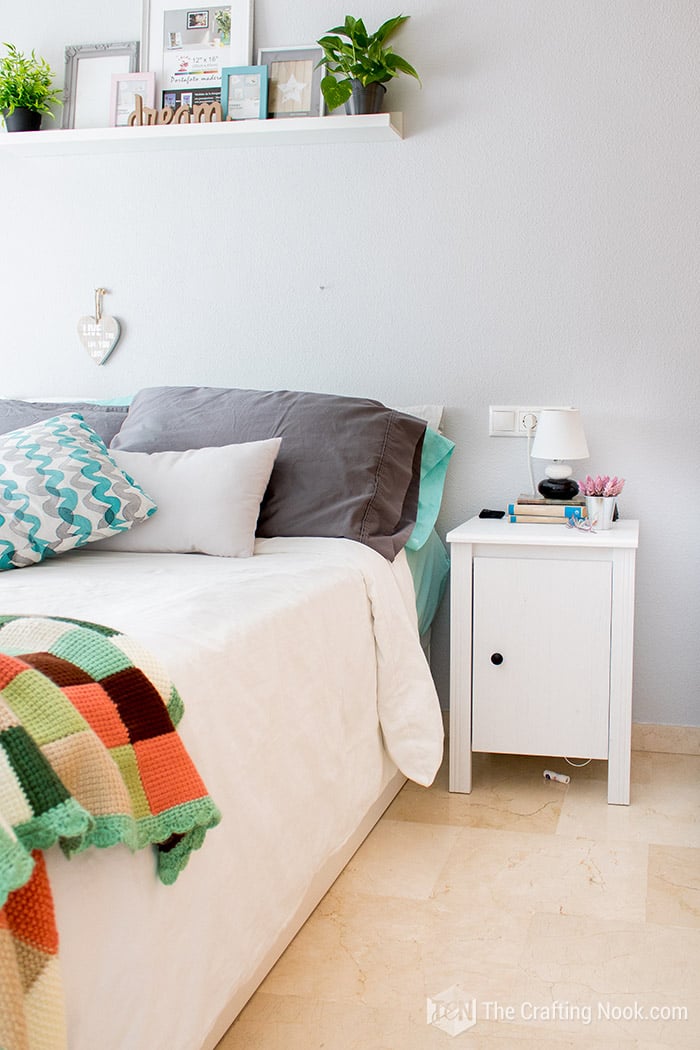 detail of the nightstand next to the bed in contrast to the gray wall