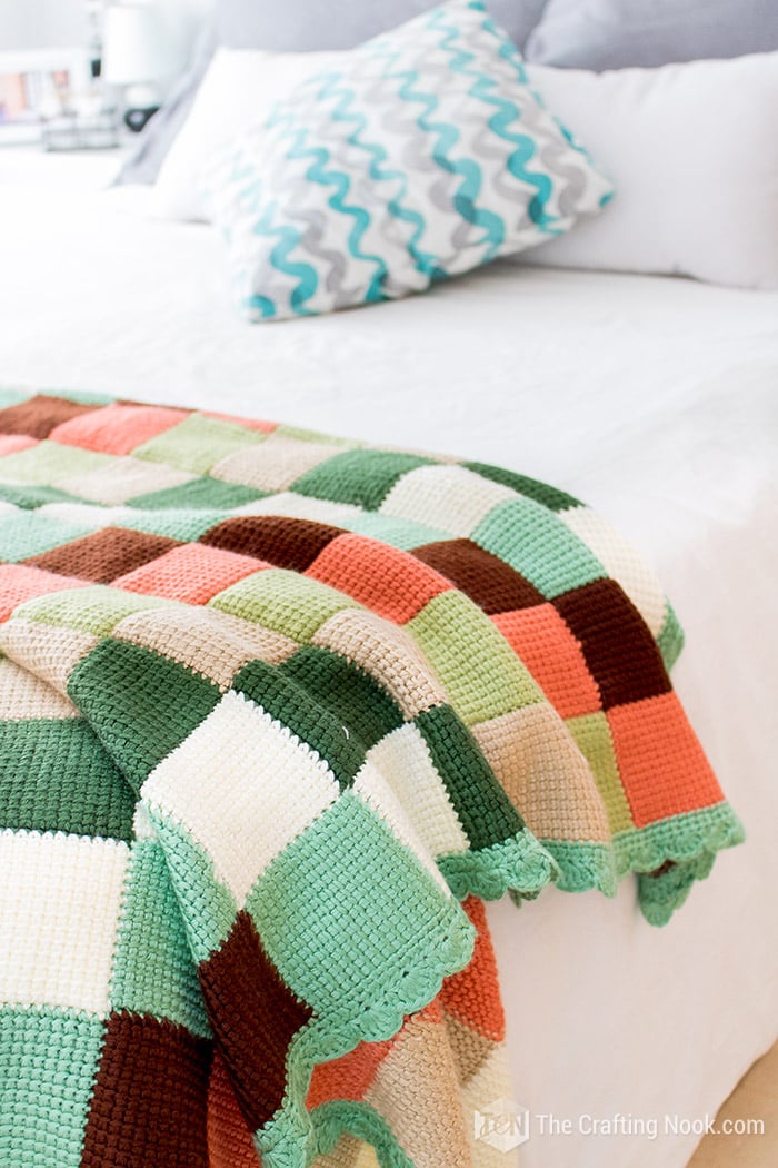 close up of knitted blanket over the corner of the bed