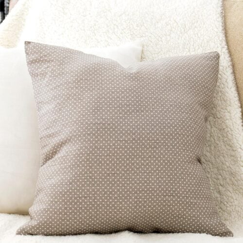 DIY 10-minute Envelope Pillow Cover Tutorial (Step by Step with Photos) The pillow is on the sofa next to another white pillow and a blanket underneath
