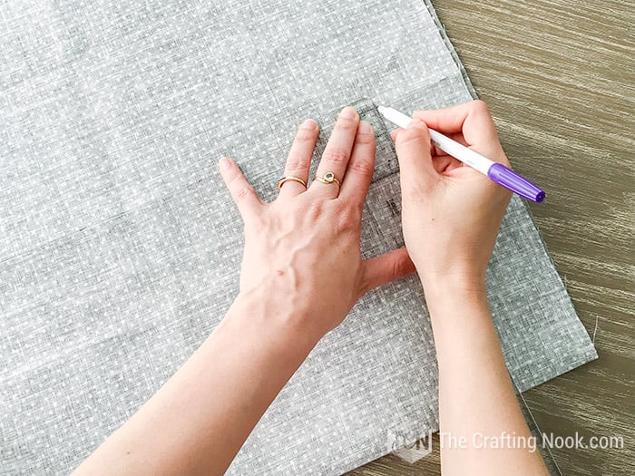 top view of hands drawing lines on the fabric