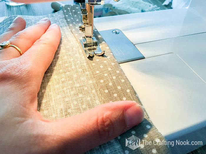 closer view of hands in machine sewing the hem