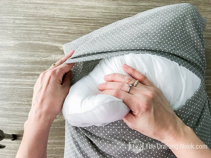 top view of hands inserting the cushion into the cover