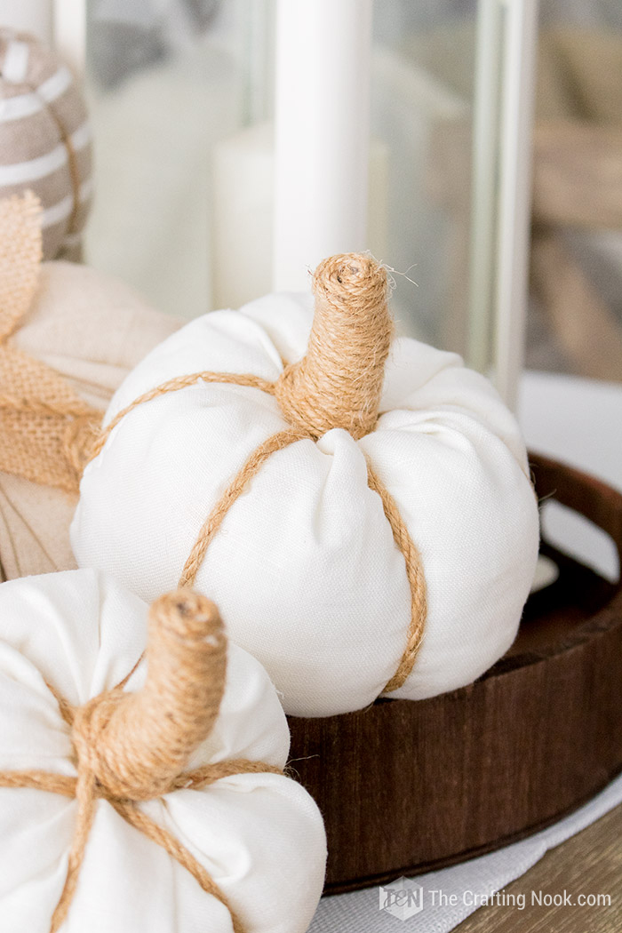 A tray holding several pumpkins made from fabric.