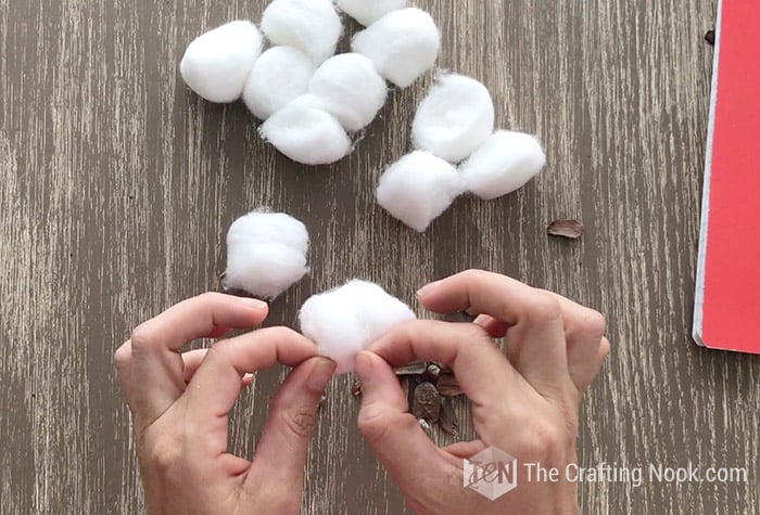 Fluffing the cotton balls by hand
