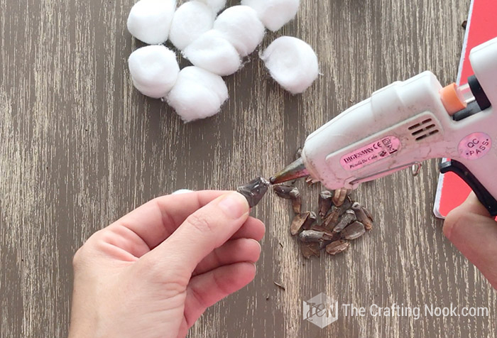 placing hot glue at the base of the pinecone scales
