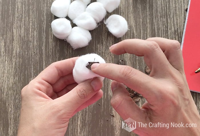 superior view placing the flake onto the cotton ball that has already been fluffed
