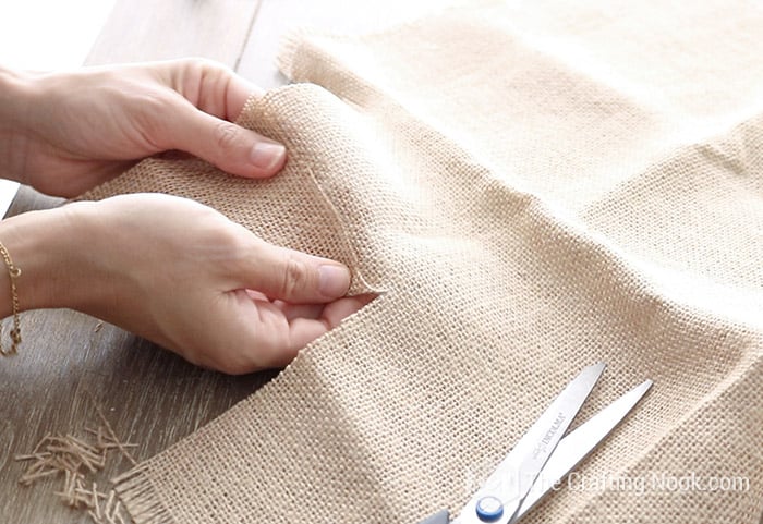 Cutting a piece of burlap to make pumpkin leaves.