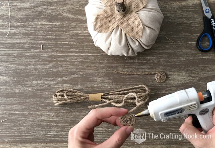 Adding finishing touches to rustic fabric pumpkin.