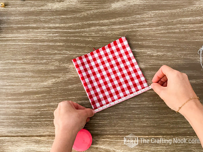 Measuring the folded fabric with a measuring tape 