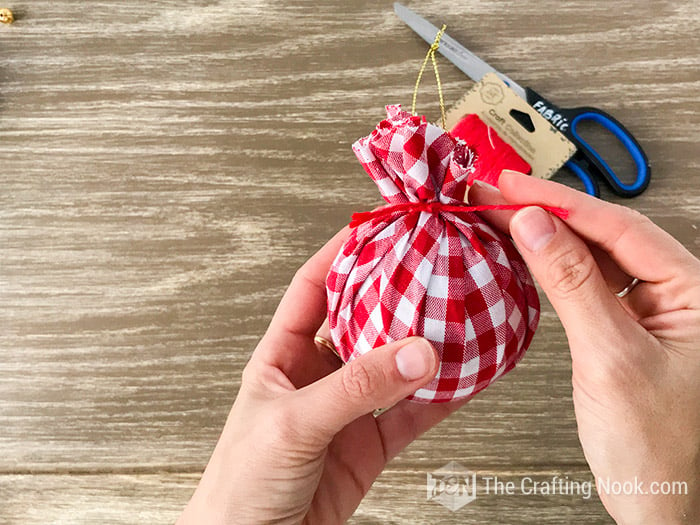 tying the ball with a red thread