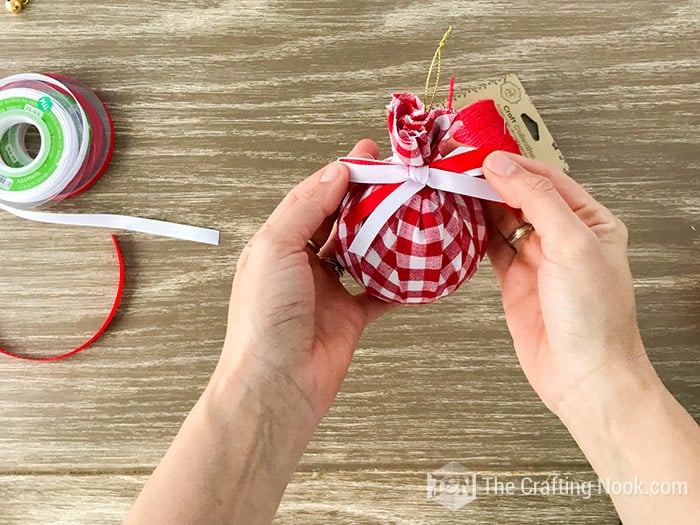 red and white bow on top of lined ball