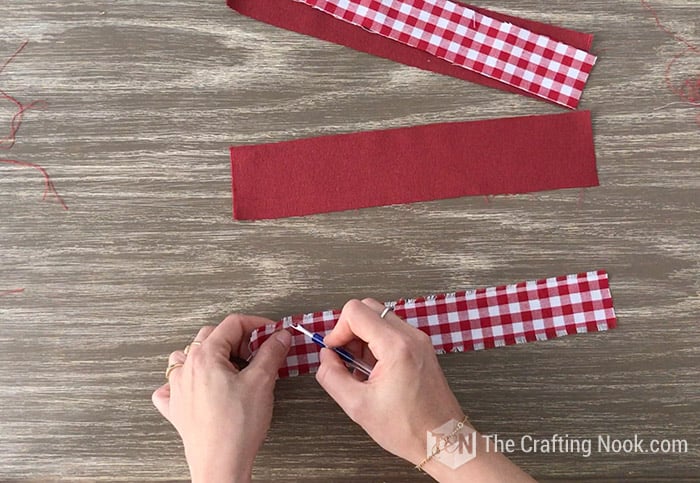 making fringes on the edges of the fabric strips with the help of a seam ripper
