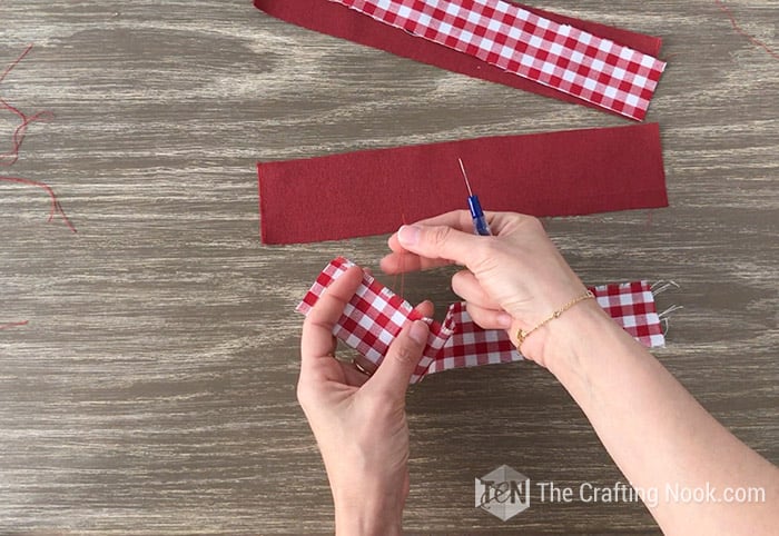 pulling the threads by hand from the edges of the fabric
