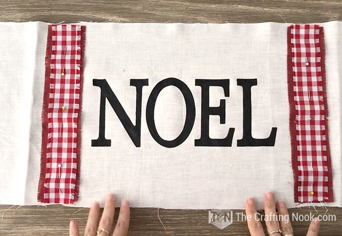 placing the strips of fabric on the sides of the word NOEL on the painted fabric
