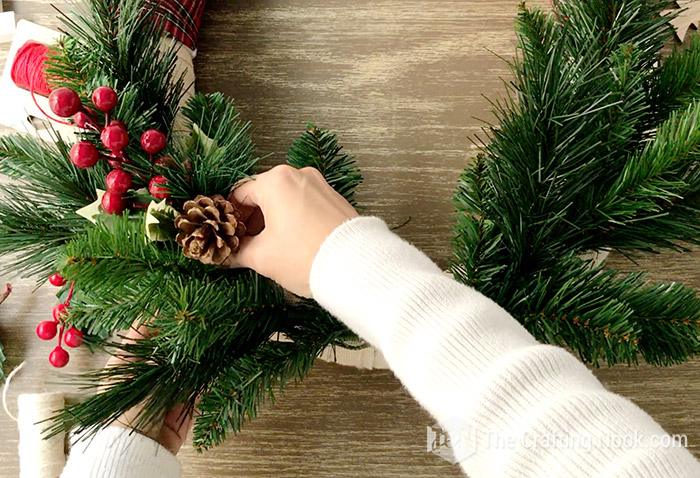 placing some cranberries spring and pine cones in both sides