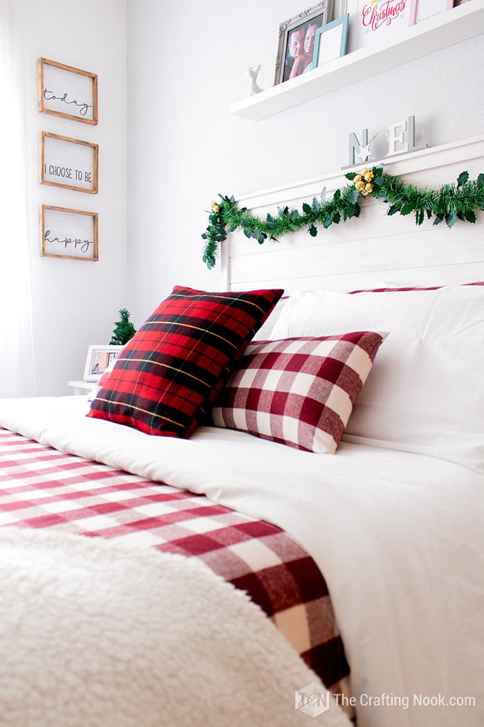 bed side image with red buffalo plaid cushions on it