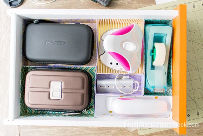 Organized desk drawer with custom cardstock dividers sized for larger electronics, tape dispensers, and desk accessories.