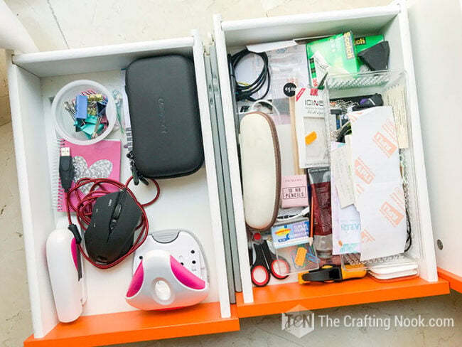 Two messy white desk drawers filled with office supplies, cables, tools, and small accessories before organizing.