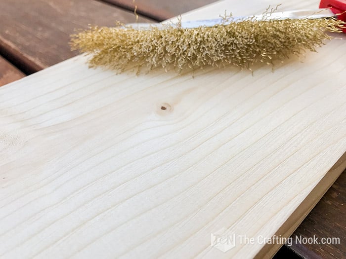 Brushing the wood boards with brass-bristle scrub brush