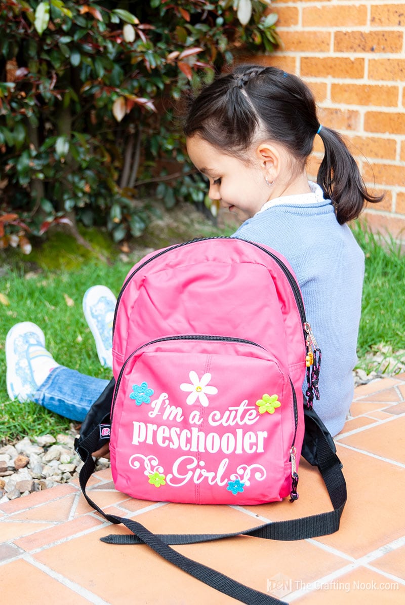 picture two of my daughter modeling Heat Transfer Vinyl Backpack decoration sitting next to her