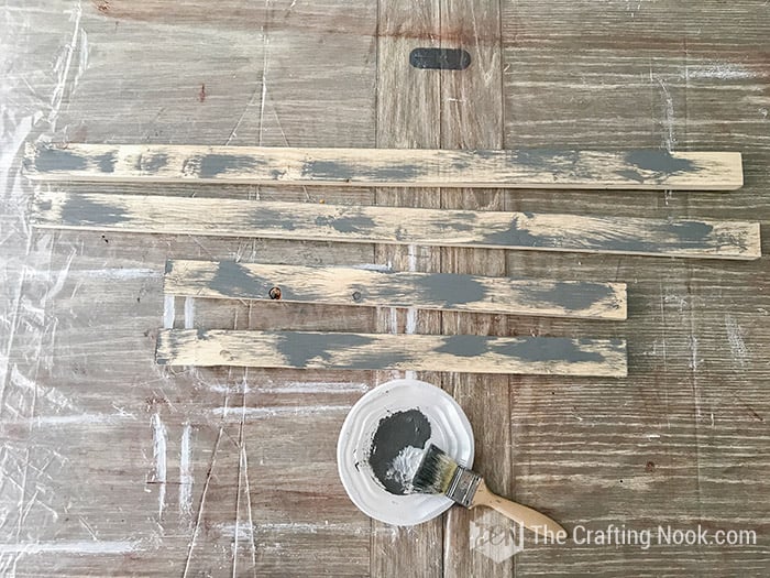 rustic wood sign frame boards painted with rough strokes of grey paint.