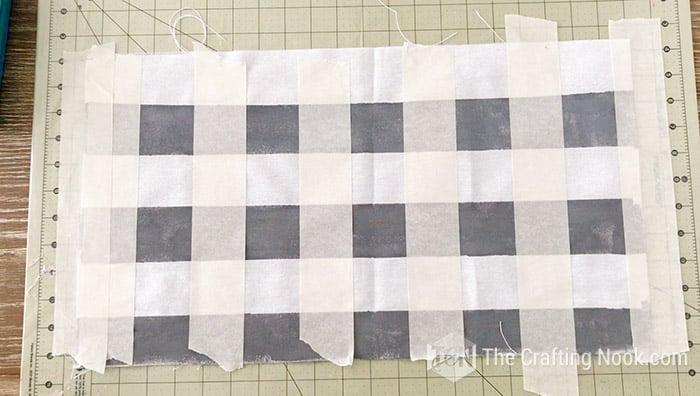 strips of tape placed vertically on the fabric