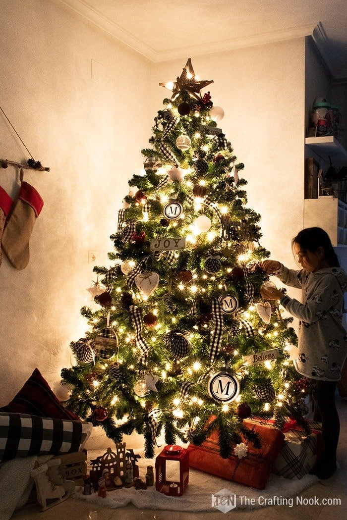 image the tree lit at night and my daughter placing some decorations
